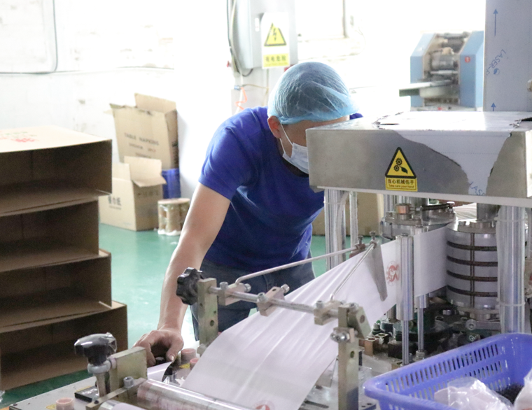 عامل مراقبة الجودة يتفقد عملية إنتاج ورق التواليت